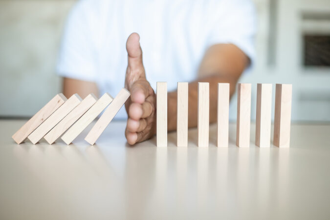 Solution concept with manual stop of wooden blocks from falling in domino line