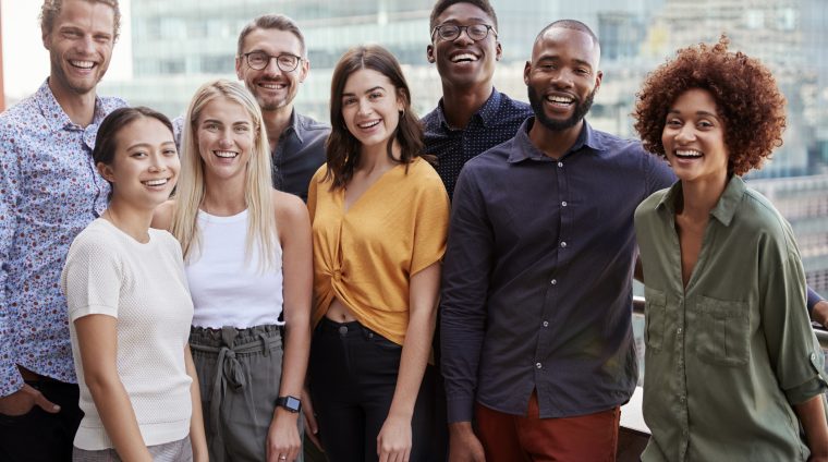 Group portrait of a creative business team standing outdoors, three quarter length, close up